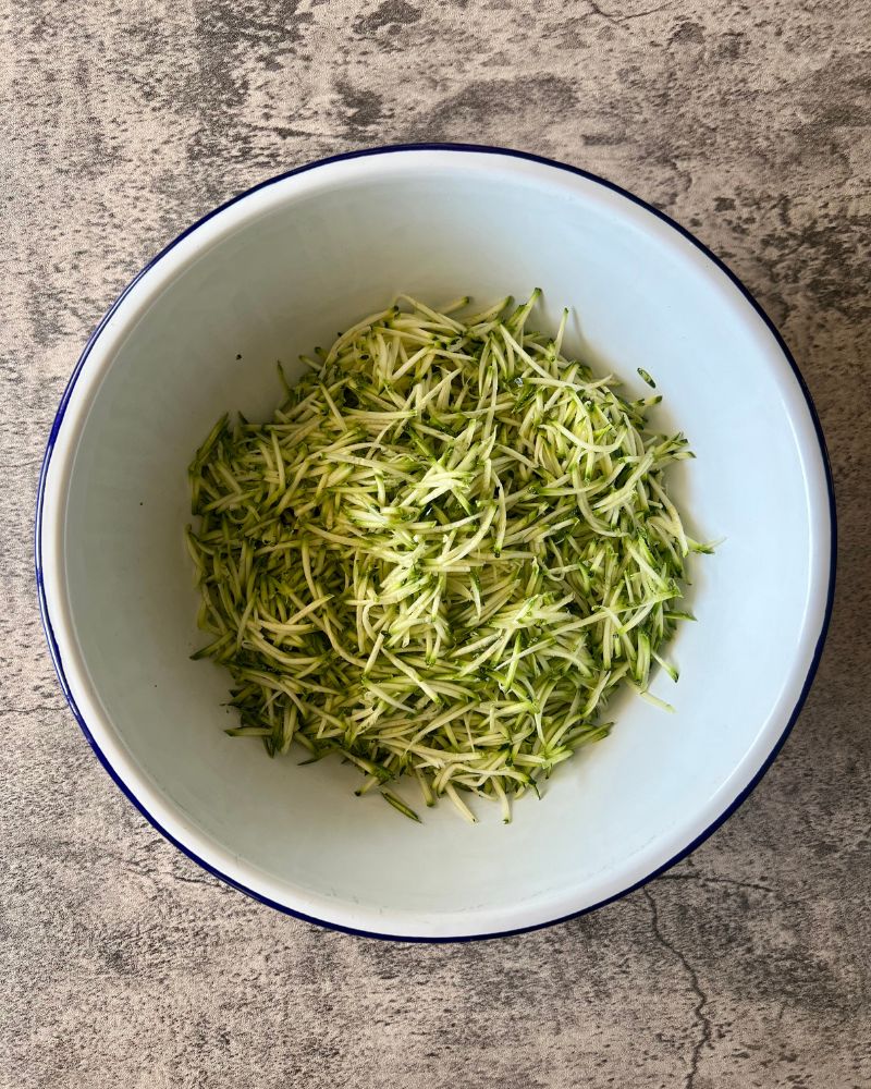 grated zucchini in a white bowl