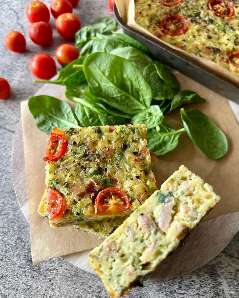 vegetable slice with tomatoes and spinach leaves in background