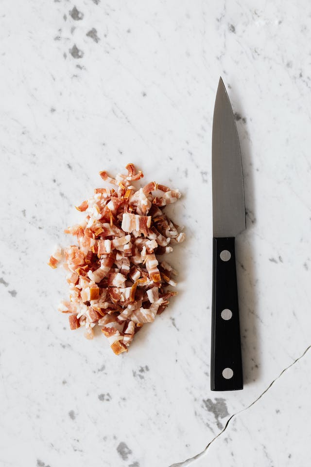 diced bacon in a pile with knife next to it