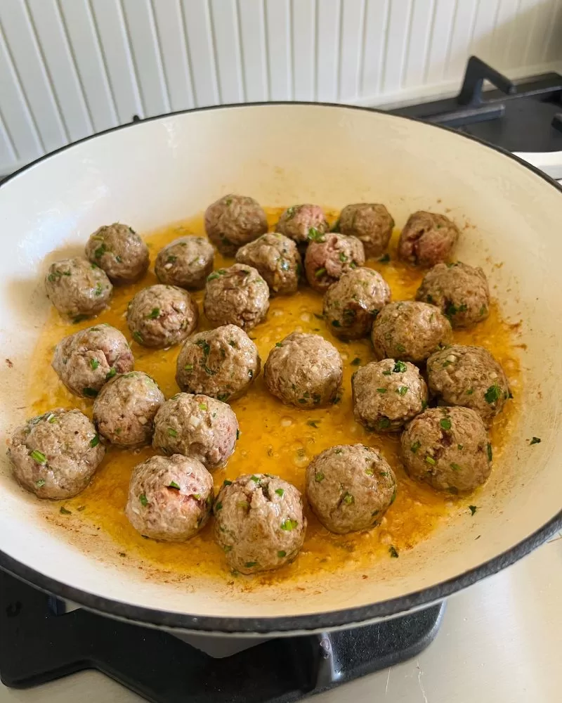 lamb meatballs cooking in a pan
