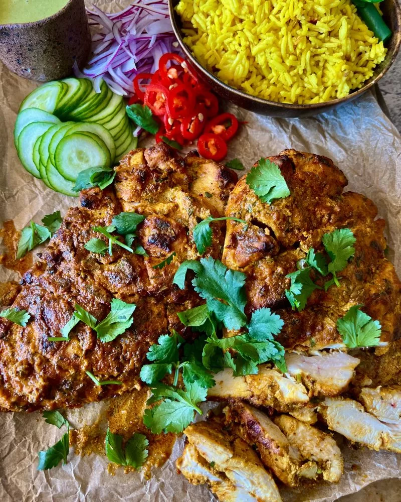 yoghurt chicken with condiments on tray.