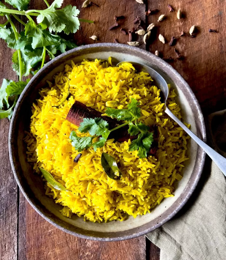 Indian Yellow rice in a bowl on dark wood background
