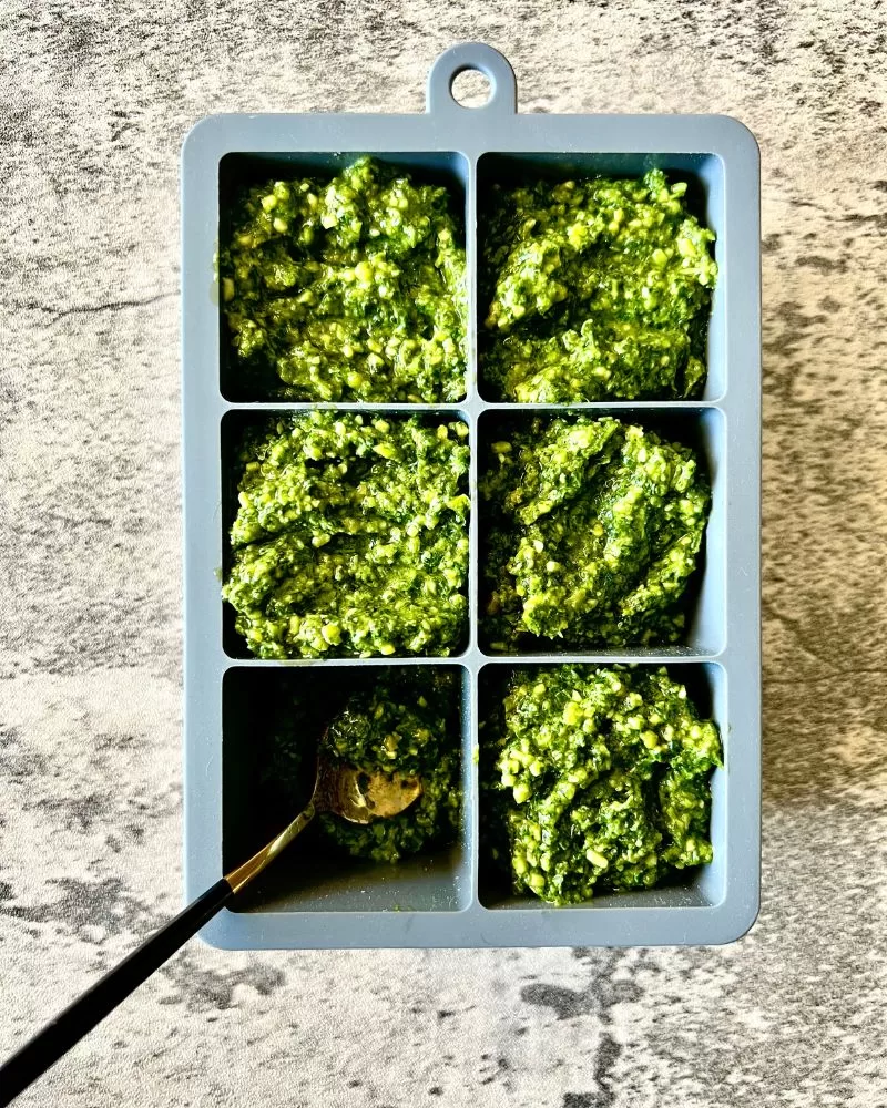 basil pesto in ice cube trays on bench top