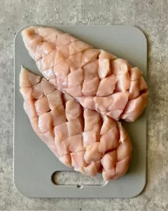 raw chicken breasts on a chopping board
