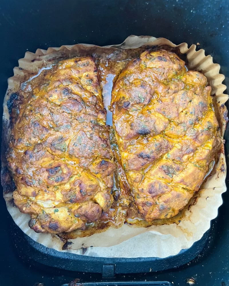 raw marinated chicken breasts in air fryer basket