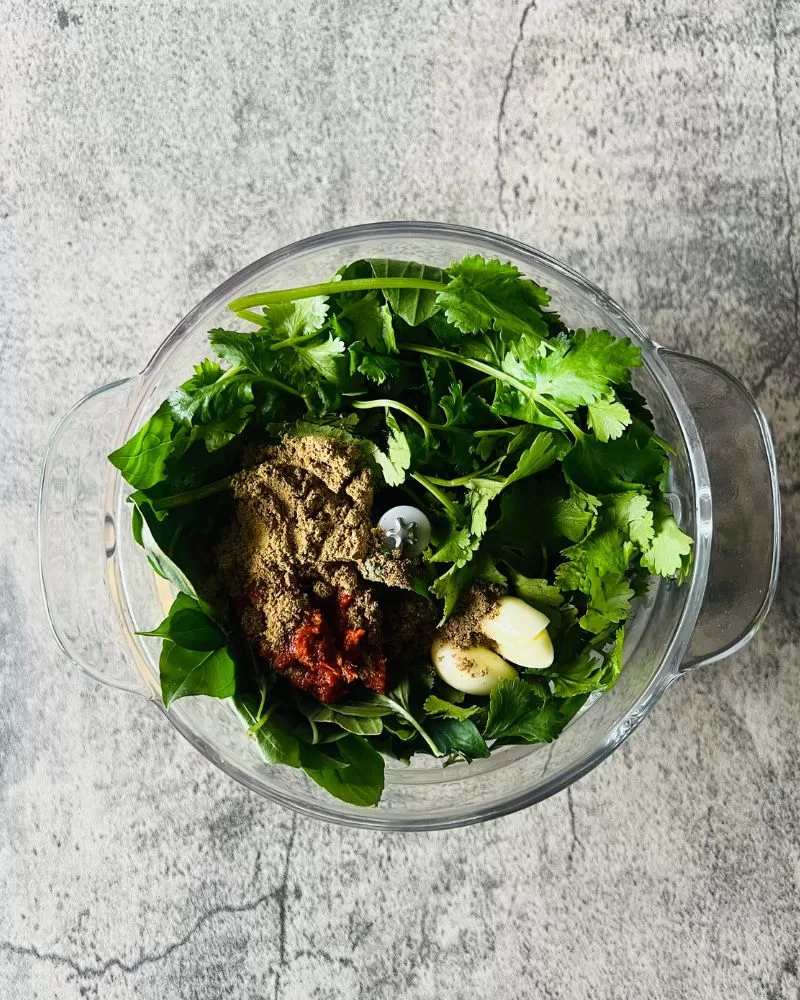 herbs, spices and garlic in a food processor bowl