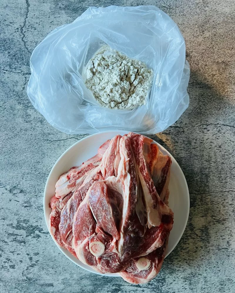 lamb chops on a plate and bag with flour in it