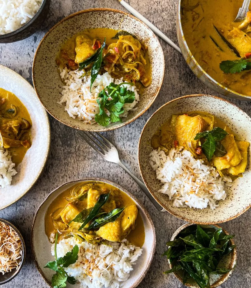 Fish curry in bowls with rice. Garnished with coriander.