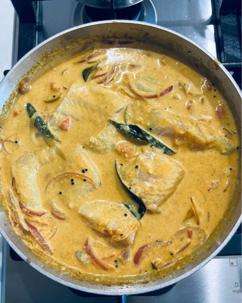 cooking fish curry in a pan