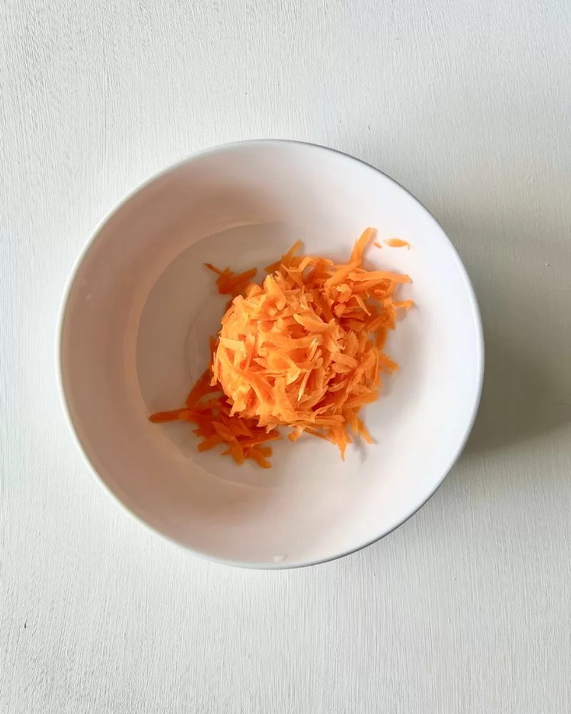 white bowl with grated carrot in it
