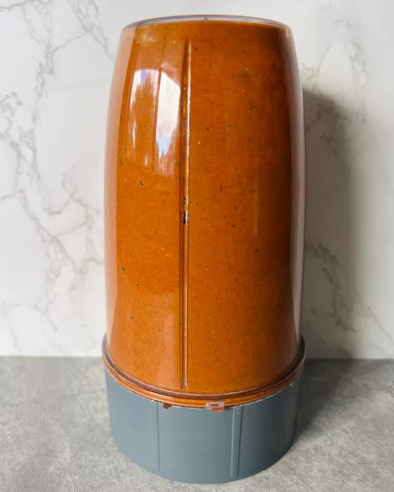 a blender with the dark orange chipotle marinade in it