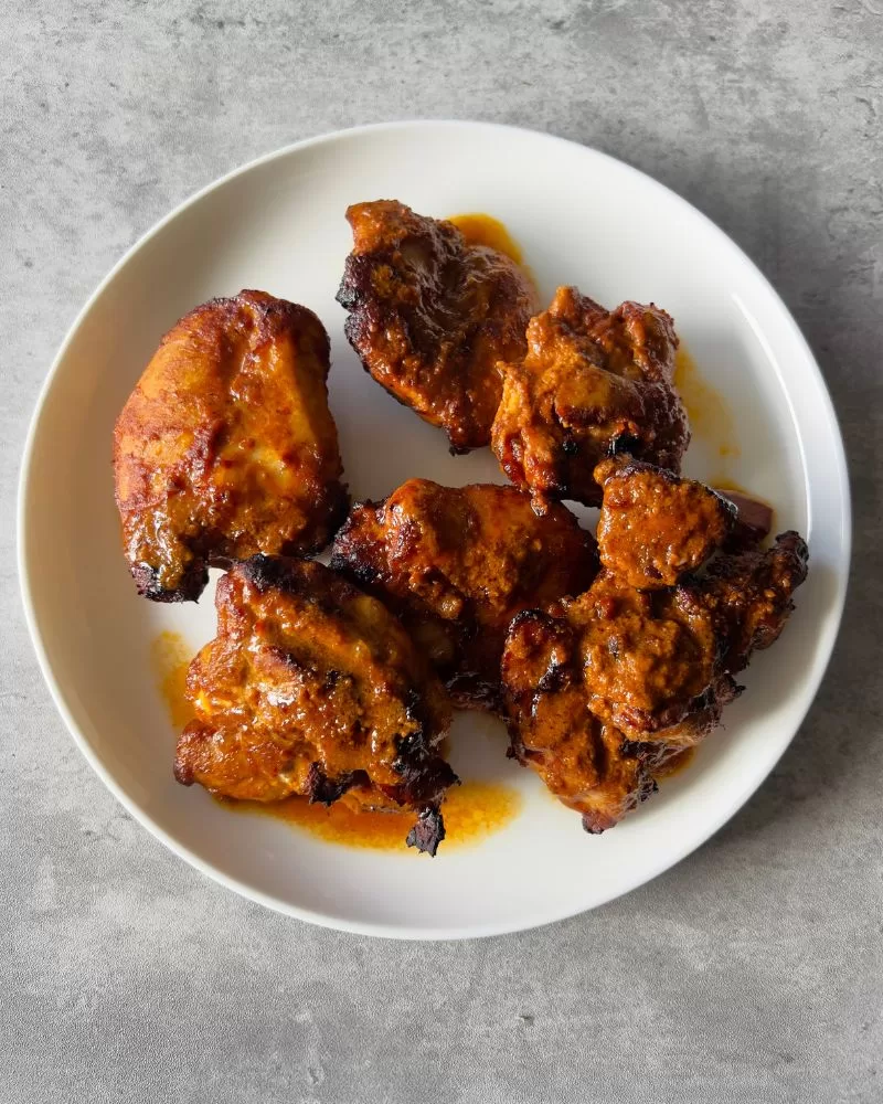 cooked chicken thighs on white plate