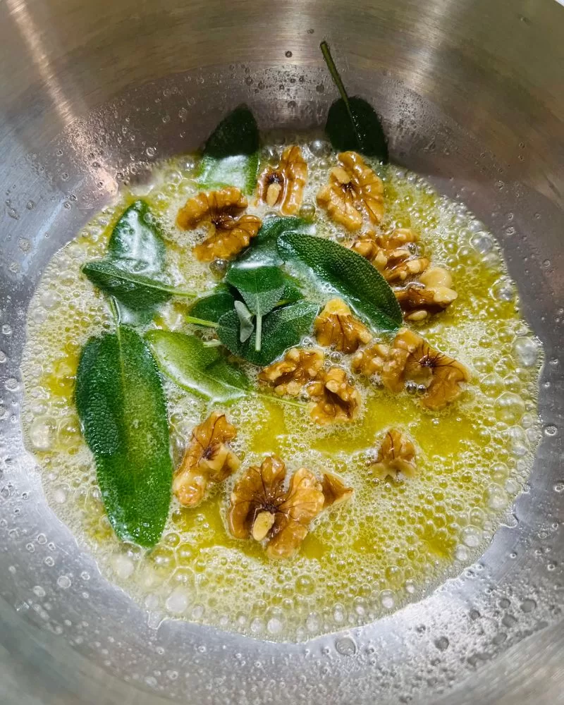 butter walnuts and sage in saucepan