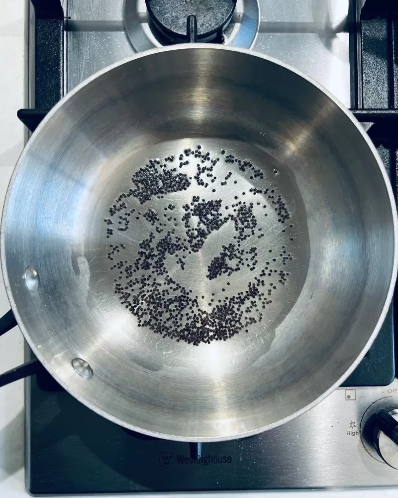cooking black mustard seeds in a pan