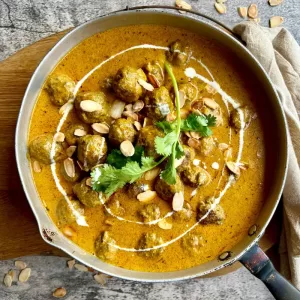 meatball curry in frying pan on grey marble background