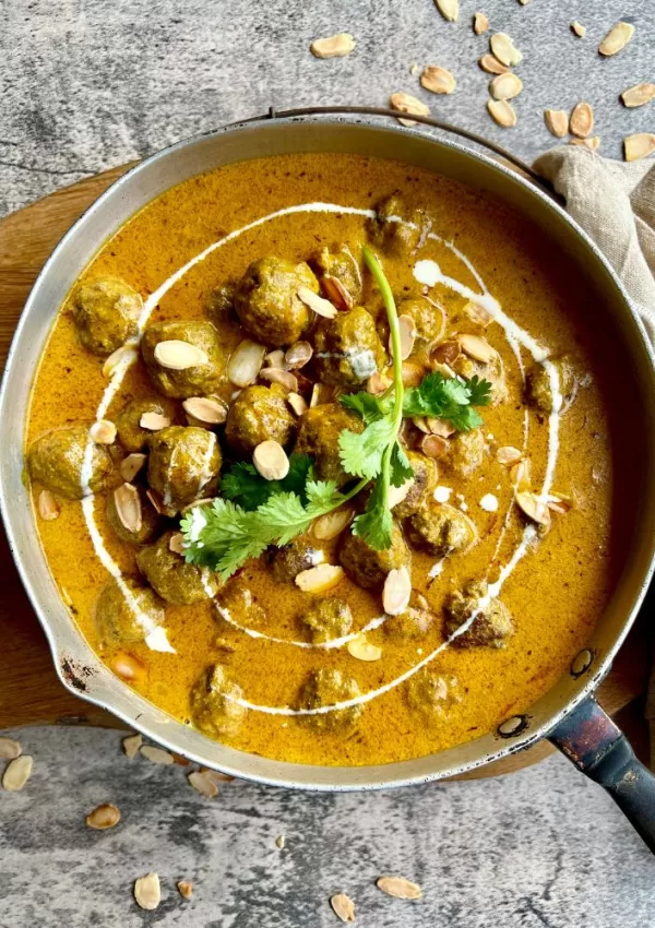 meatball curry in frying pan on grey marble background