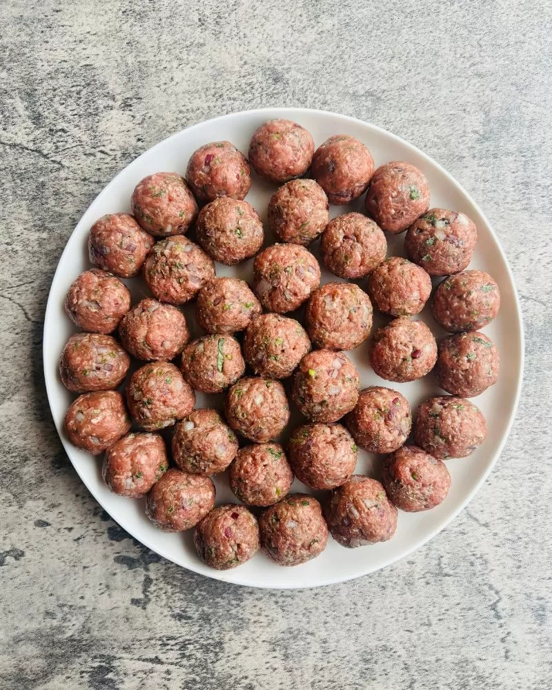 meatballs rolled into balls on a white plate