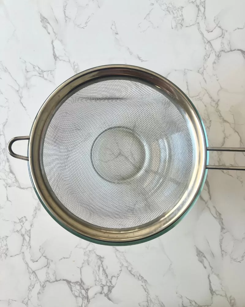 wire sieve over glass bowl