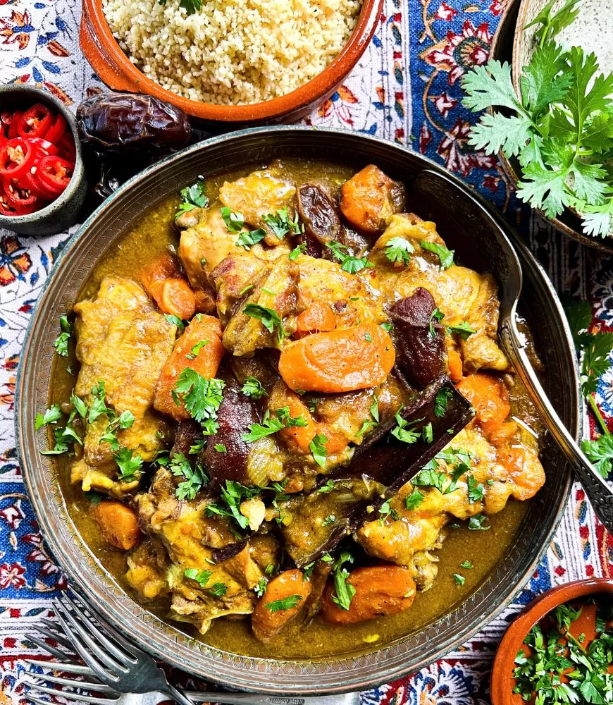 Moroccan Chicken Tagine in bowl with couscous, chilli, coriander in small bowls