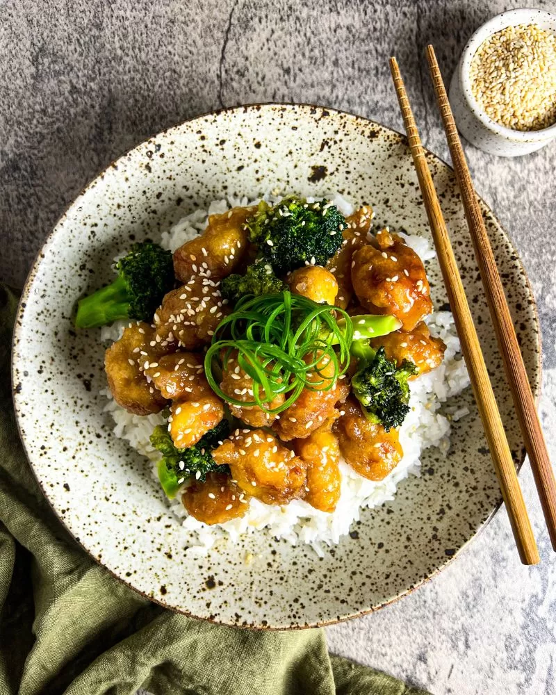 crispy lemon honey chicken in bowl with chopsticks and green napkin