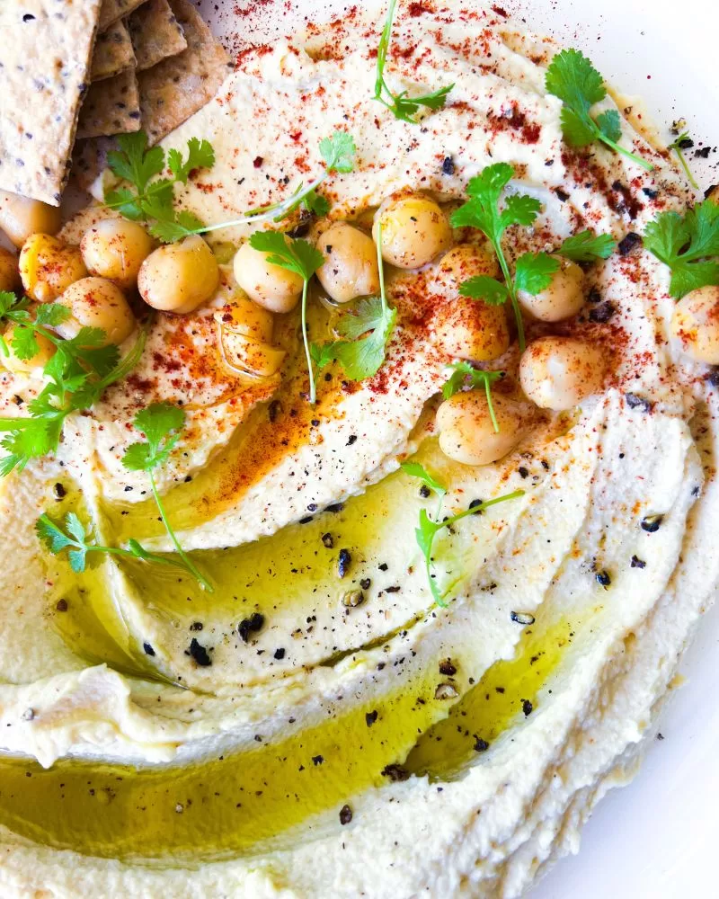 close up of hummus and garnishes