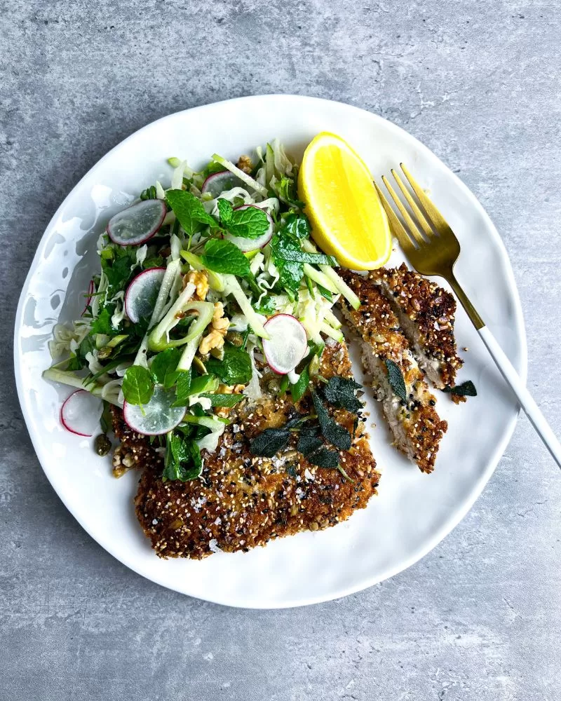 sliced chicken schnitzel on white plate