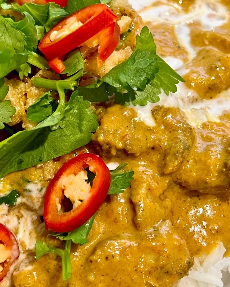 close up of chicken curry with chilli on top