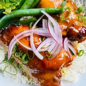 sticky chicken with sliced onions, green beans on rice