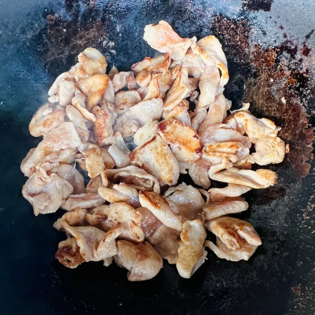 Marinated chicken browning in a hot wok