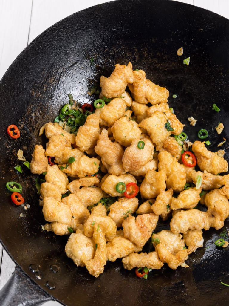 Crispy salt and pepper chicken tossed with garlic, chilli and spring onion in a wok
